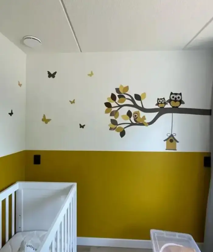 Okergele babykamer met uiltjes op tak muurdecoratie